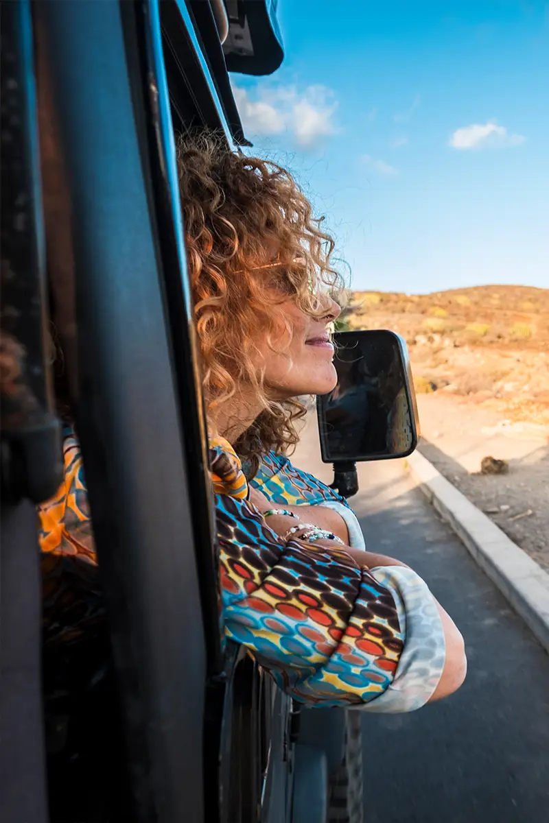 Zwei Frauen fahren entlang der Küste mit einem Auto und genießen ihre Freiheit